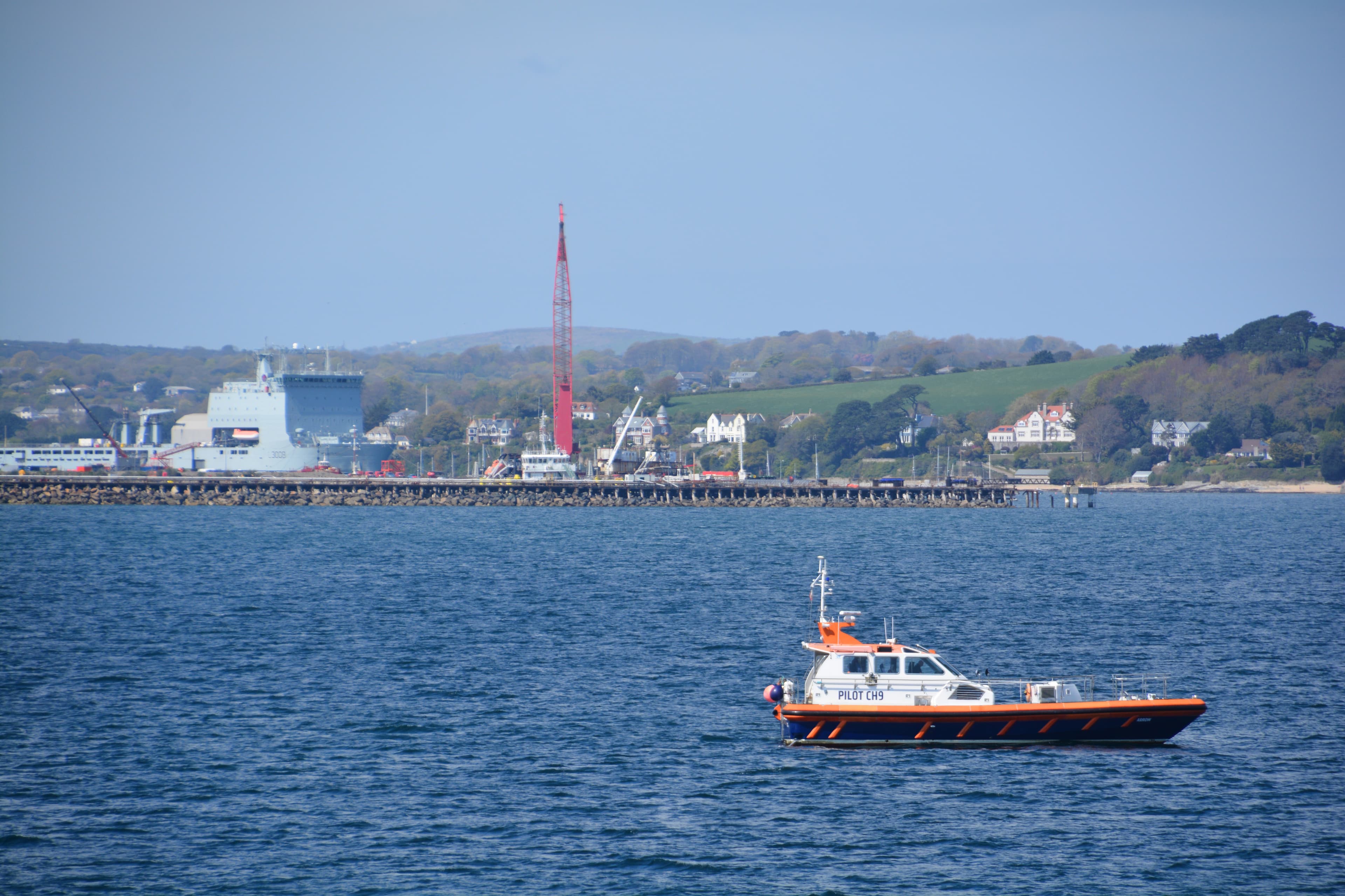 The Falmouth pilot boat in Carrick Roads, with the docks beyond