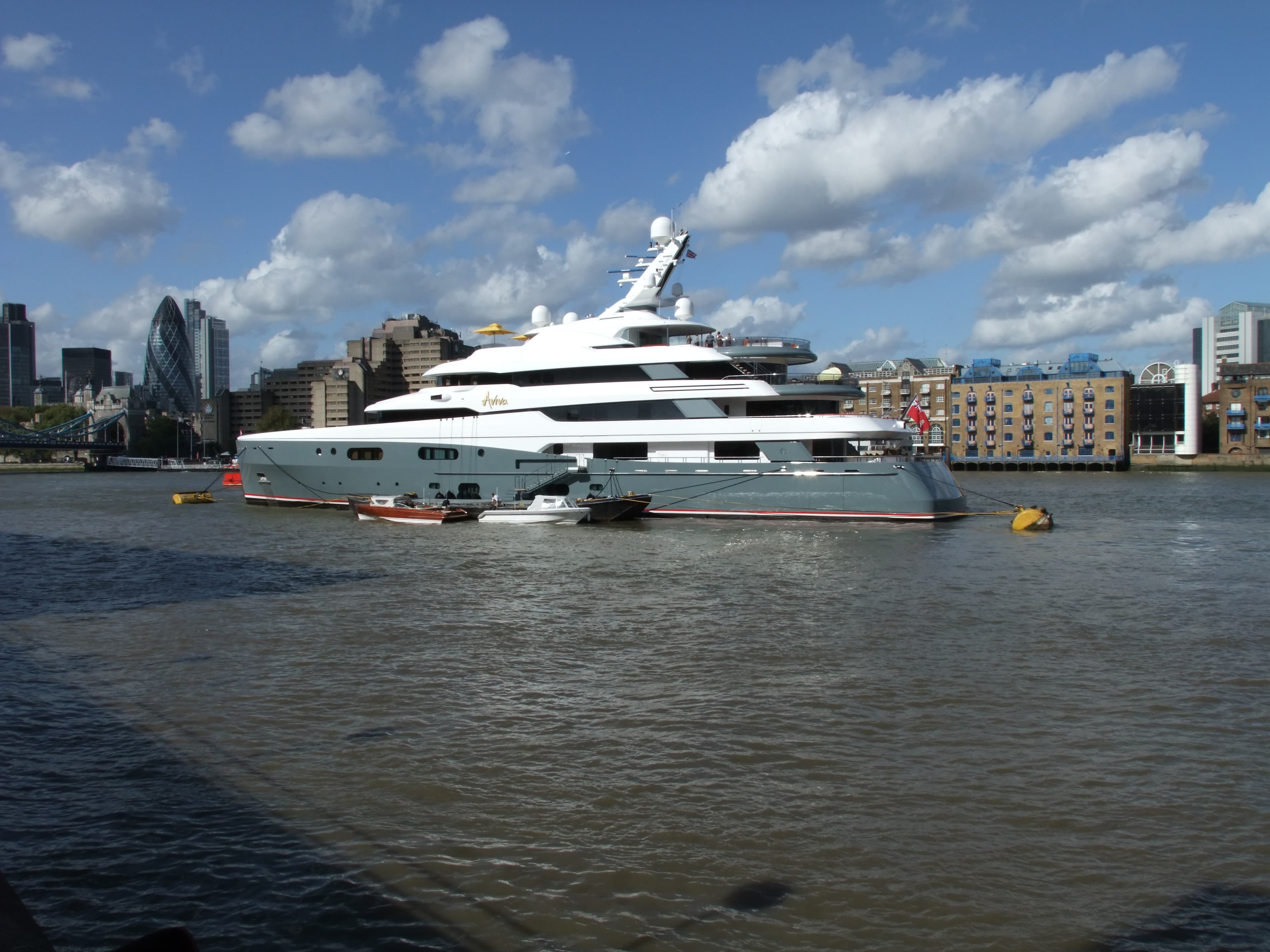 A superyacht moored on the River Thames, the City beyond